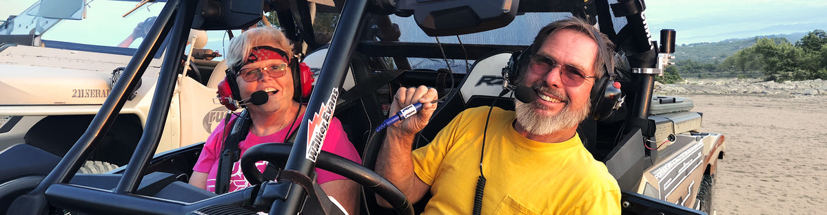 A Rugged Radios customer holds up his Rugged® OFFROAD connector attaching his helmet kit to his headset